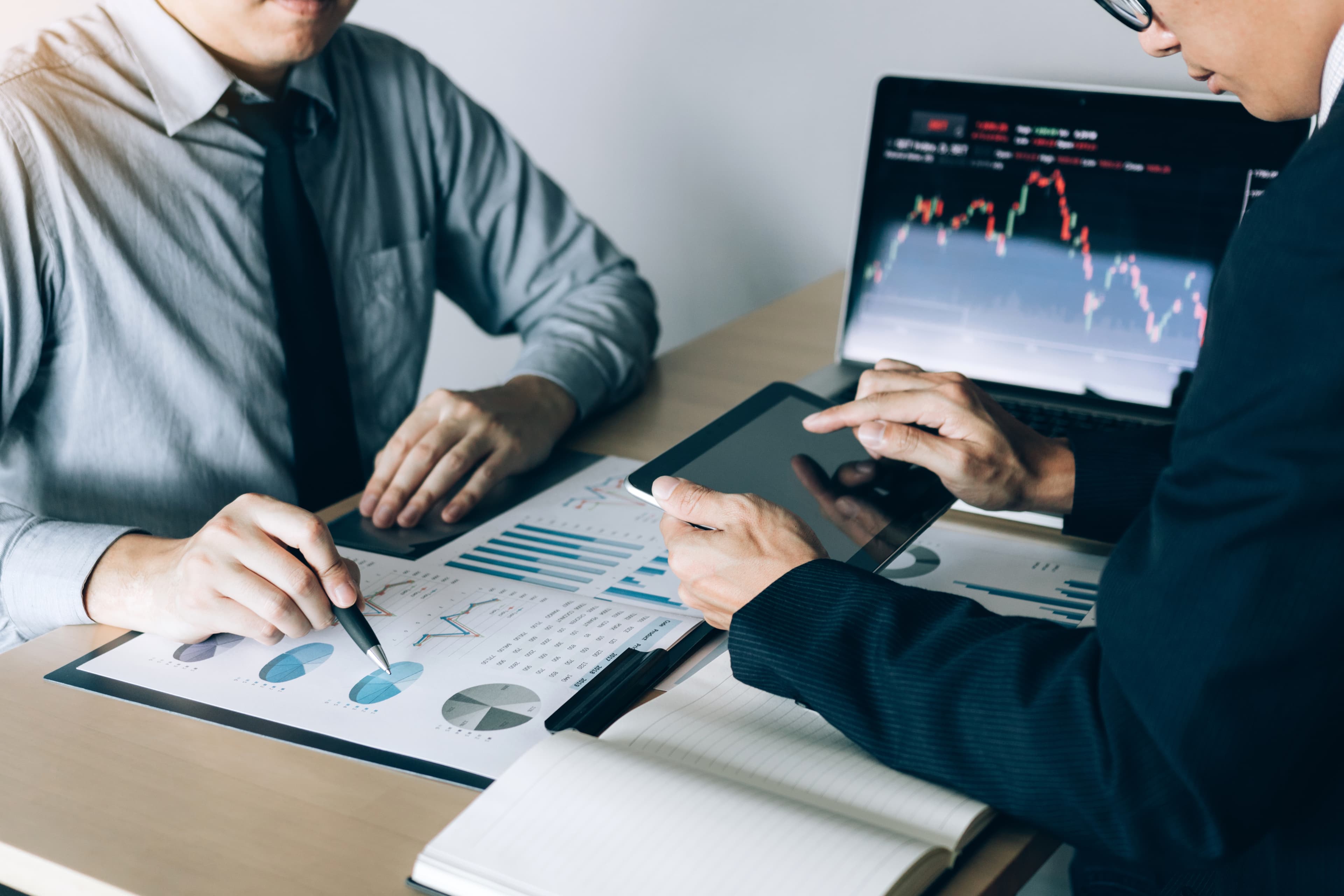 Two people reviewing investment charts