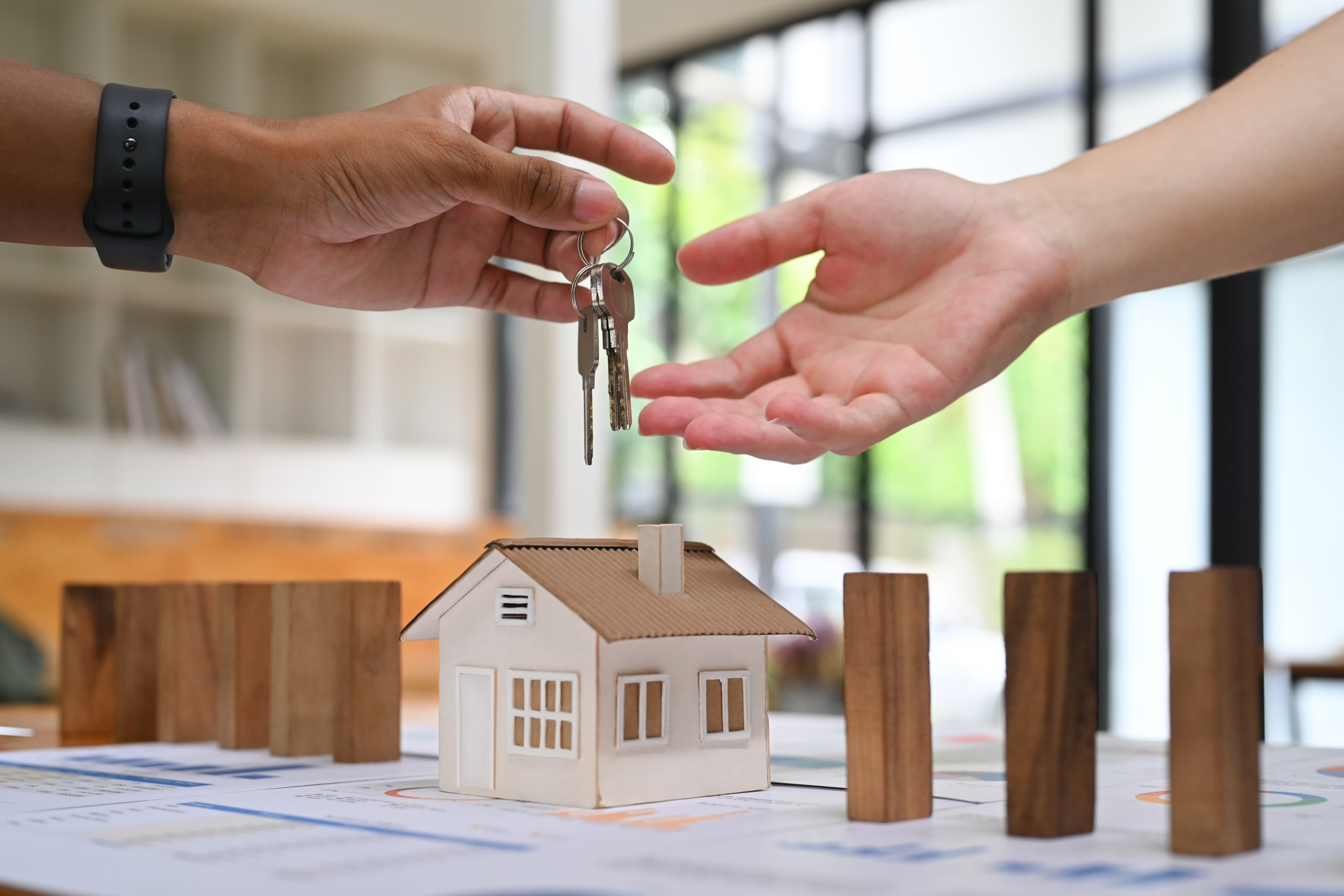 Handing over keys above a property floor plan